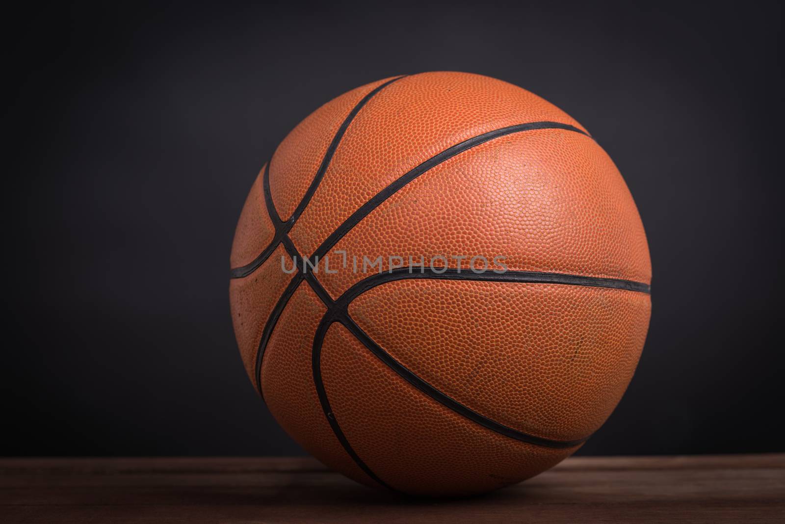Closeup old basketball basket ball on wooden and black background