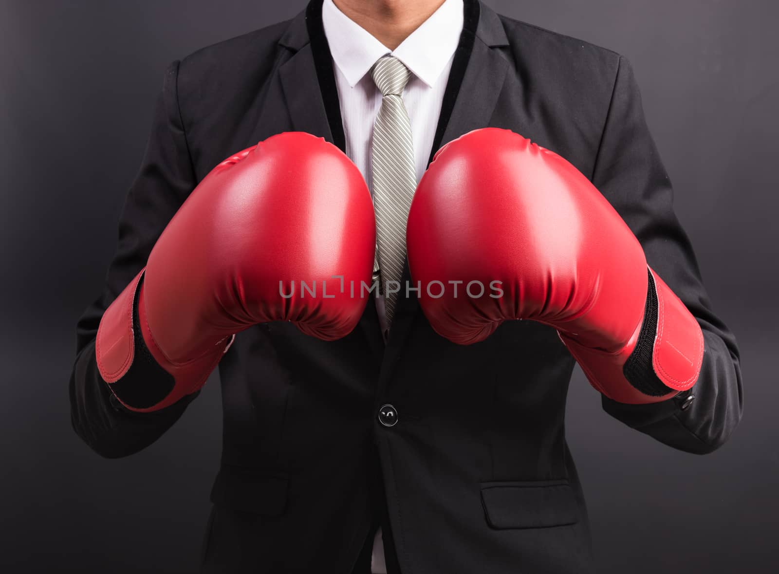 Young businessman with boxing gloves isolated on black background