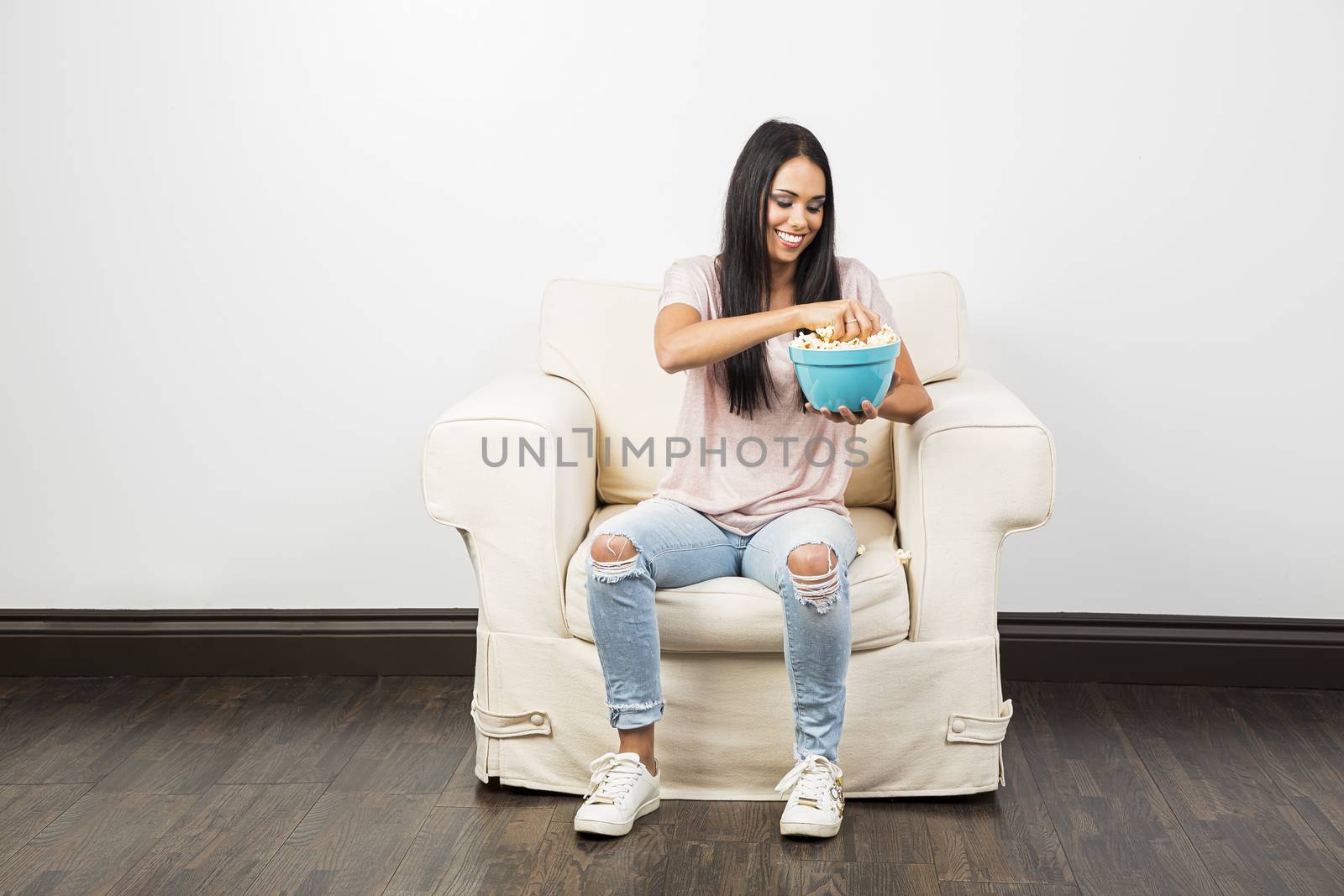 girl taking a handful of popcorn from a bowl