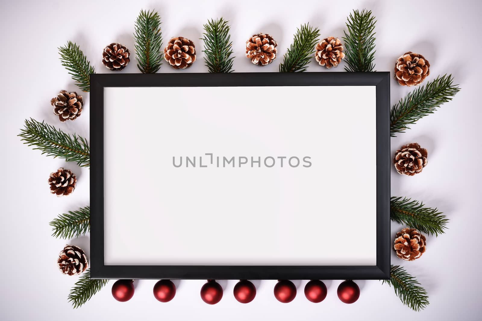 Photo frame with pinecones, evergreen branches and Christmas decoration by Mendelex
