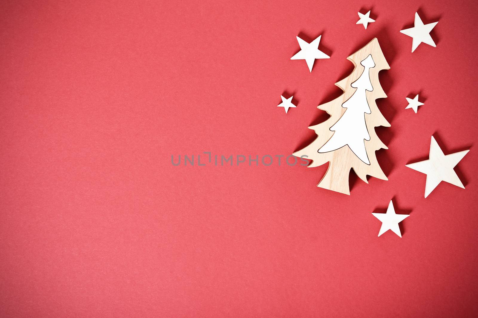 Christmas and New Year composition. Seasonal greeting card concept with white Christmas tree and stars on red background. Christmas, winter, new year concept. Flat lay, top view, copy space. 