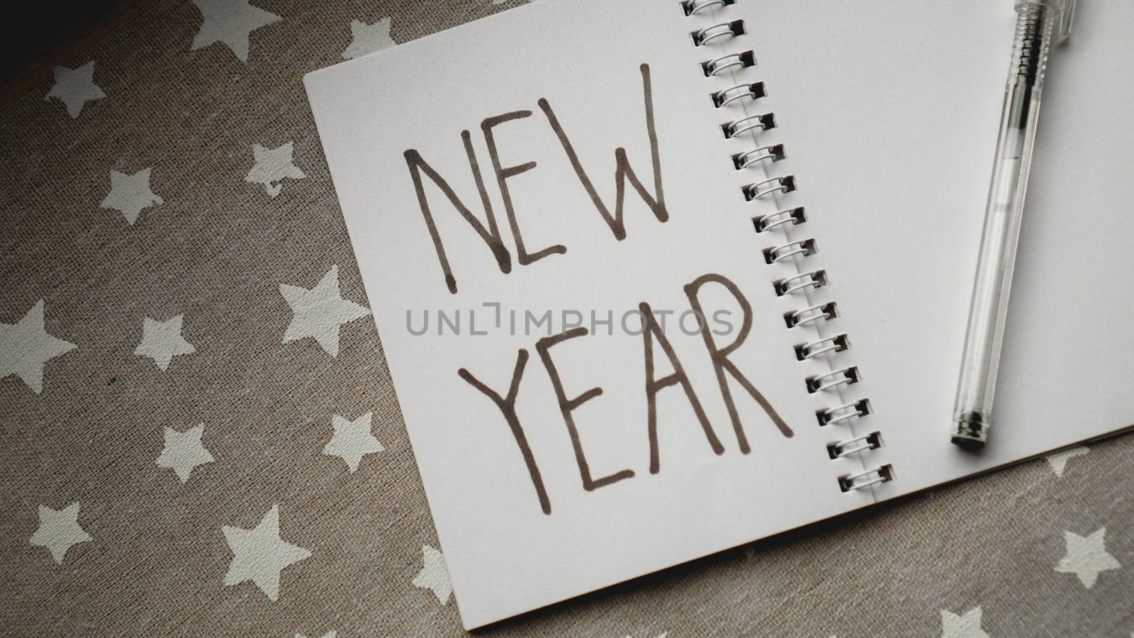 Notebook with pen to write goals of new year on christmas background