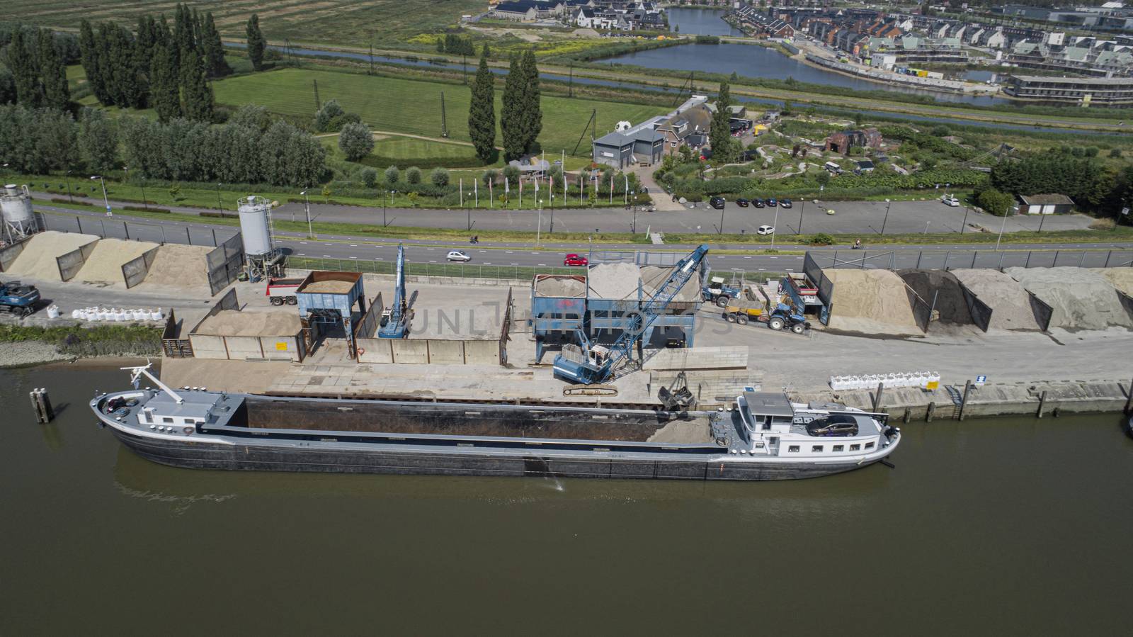 Loading barge with sand and rubble on a small berth. Freight transport logistics