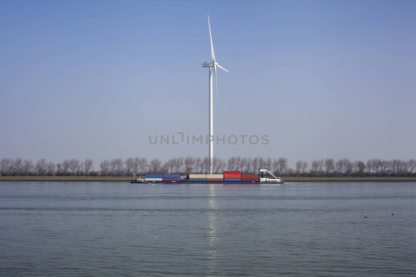 Netherlands, New Waterway. Container ship in front of modern windmill shipping, transport and heavy industry nera Maasvlakte 2.