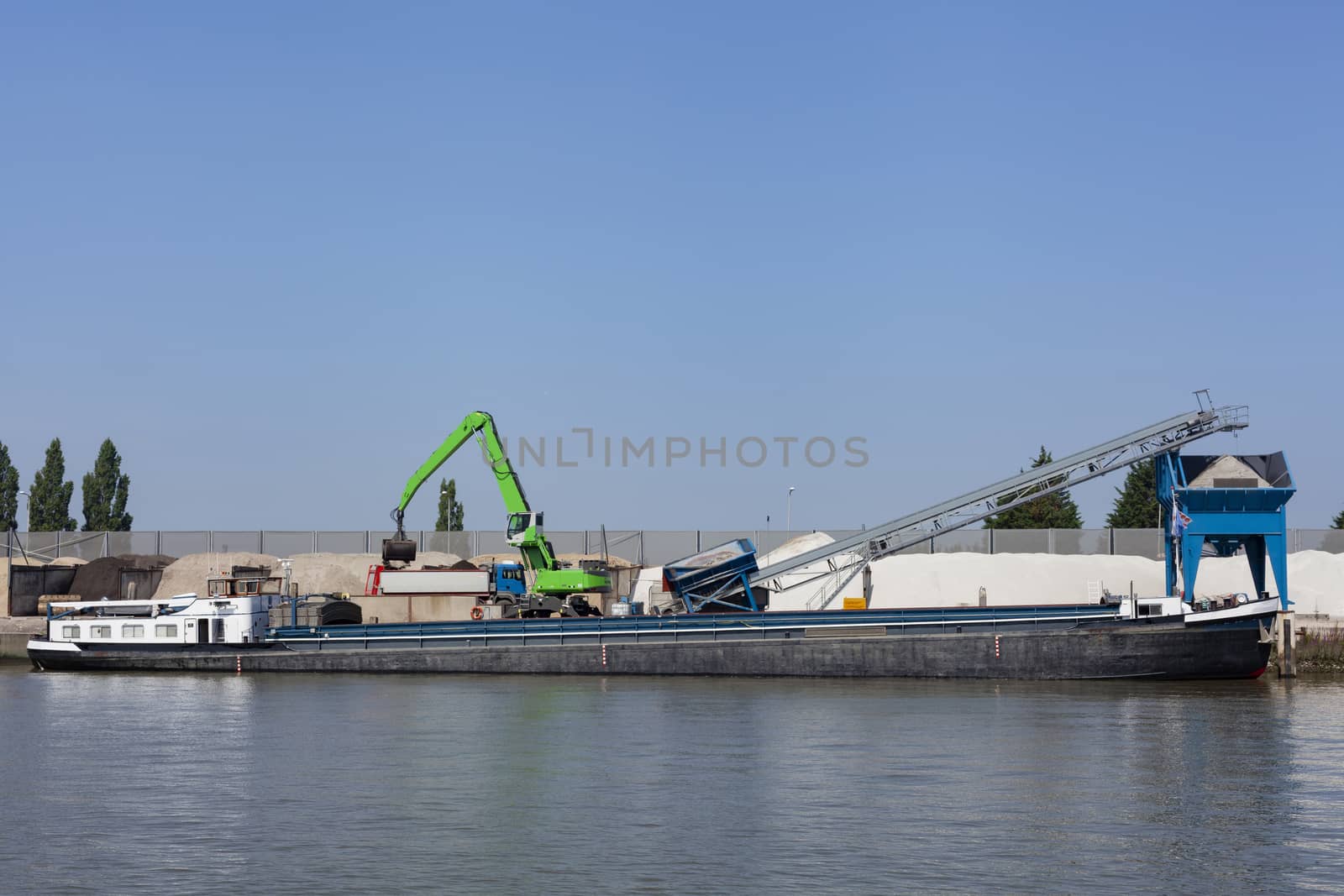 Loading barge with sand and rubble on a small berth. Freight tra by Tjeerdkruse
