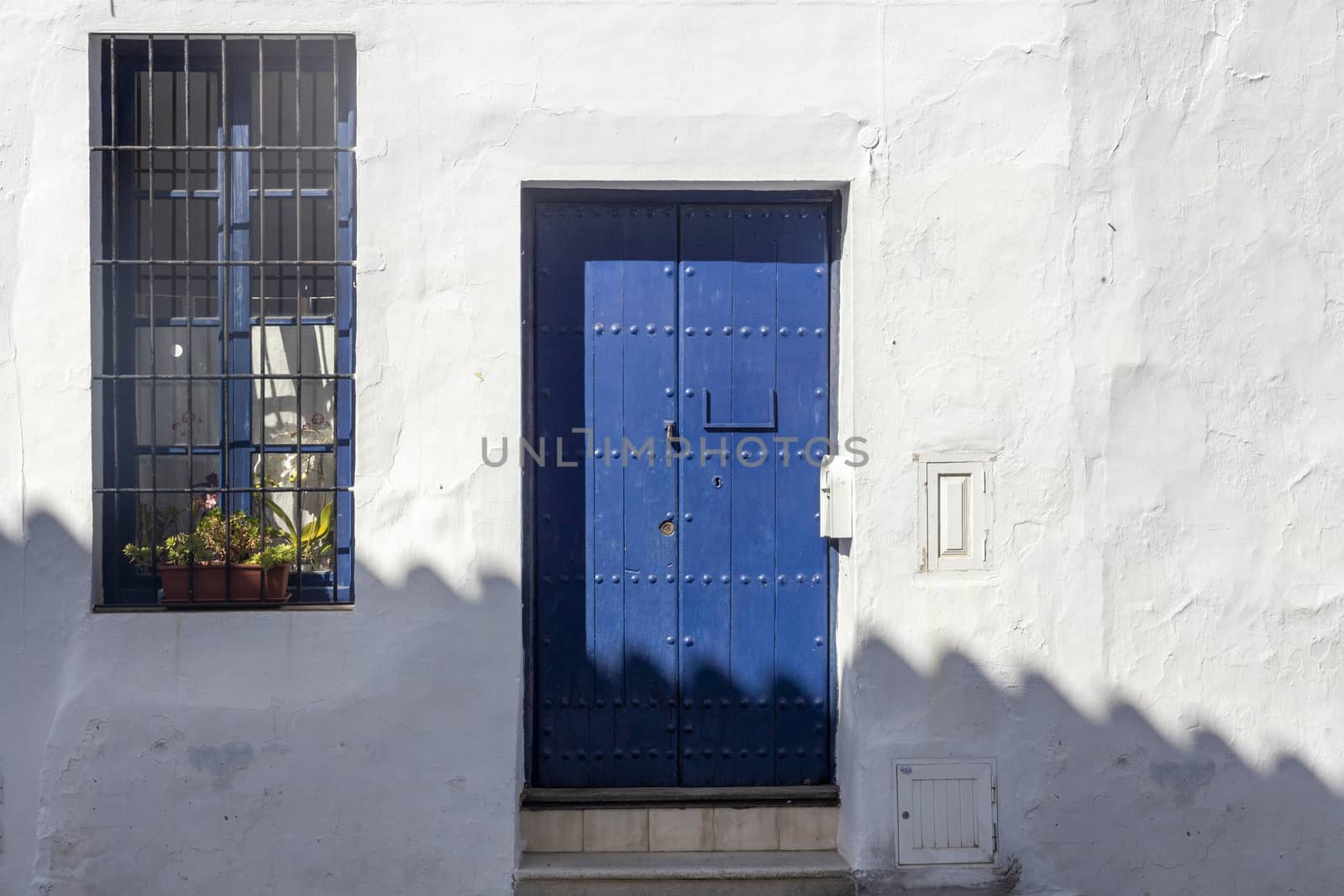 Vintage window and blue door on old traditional house in Andalusia, Spain
