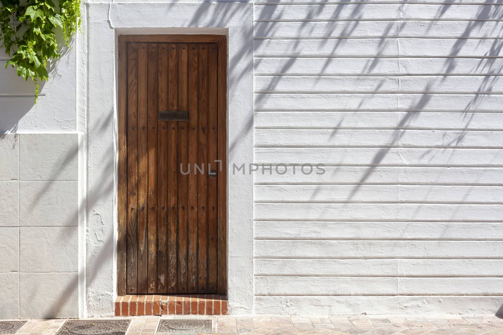 Closed Old vintage wood Door with door lock in white concrete wall, empty abstract interior, square background texture