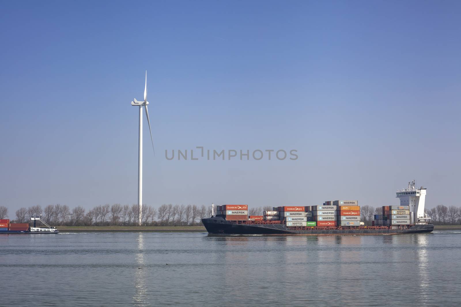 Netherlands, New Waterway. Container ship in front of modern windmill shipping, transport and heavy industry nera Maasvlakte 2.