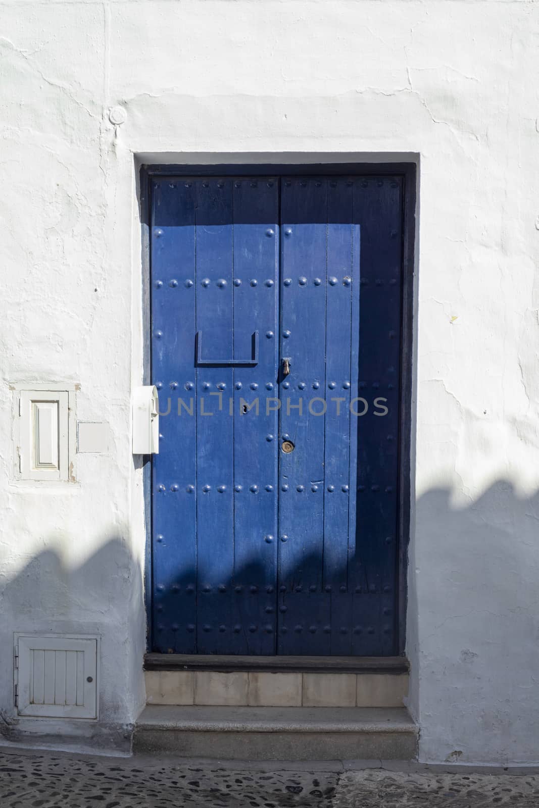 Vintage window and blue door on old traditional house in Andalus by Tjeerdkruse