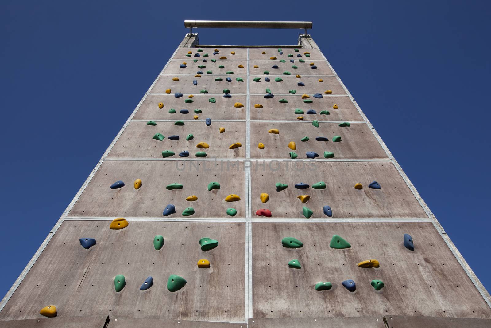 Background of empty climbing wall in a climbing center adventure park against blue sky