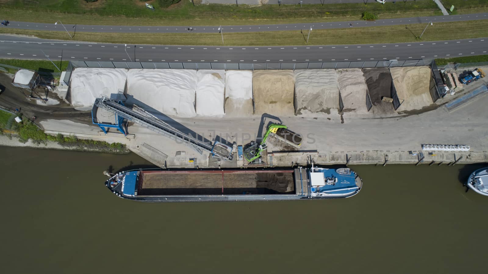 Loading barge with sand and rubble on a small berth. Freight transport logistics in the netherlands