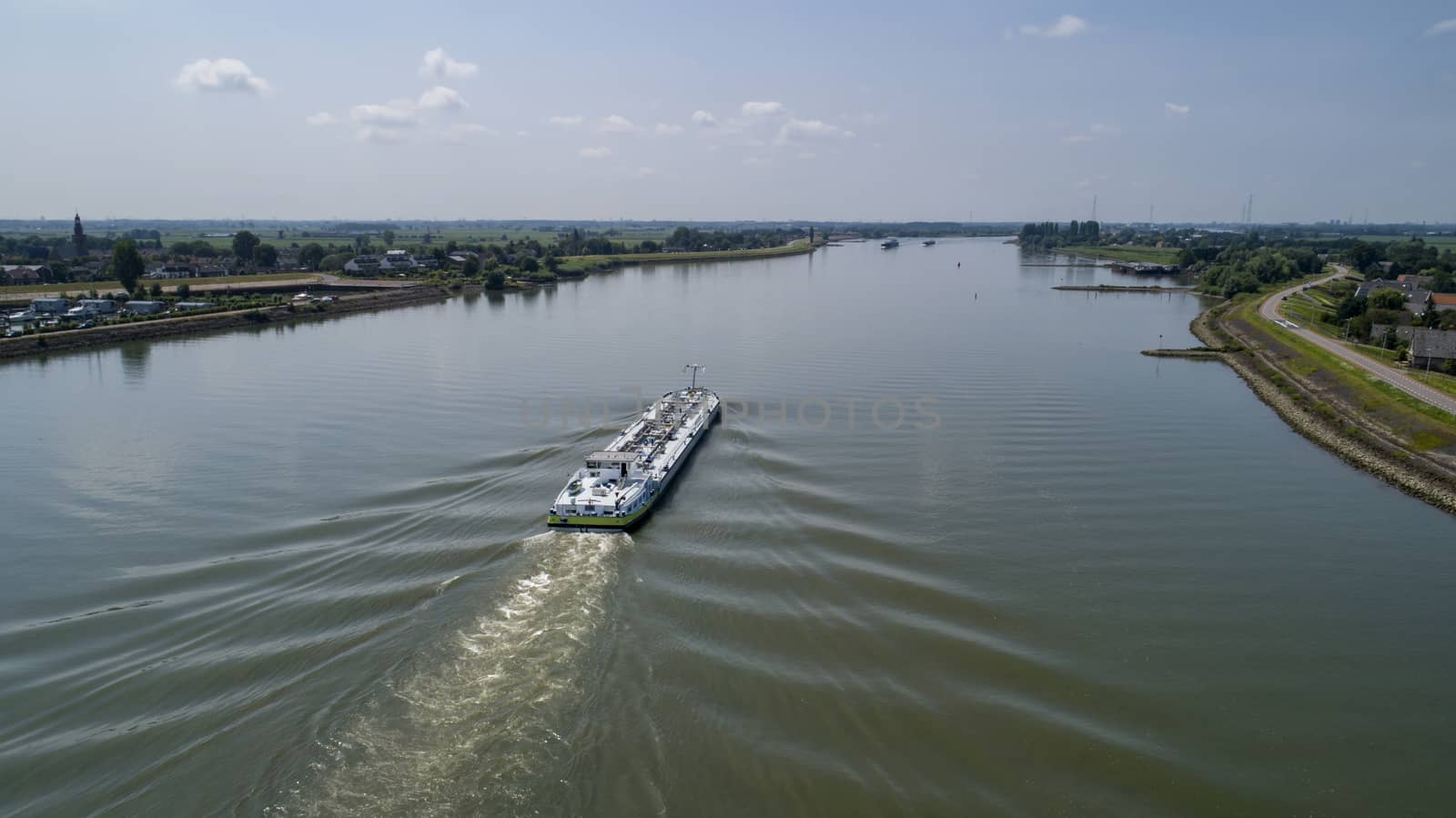 Aerial view:Barge with cargo on the river. River, cargo barge, highway with cars.. Cargo ship on the river