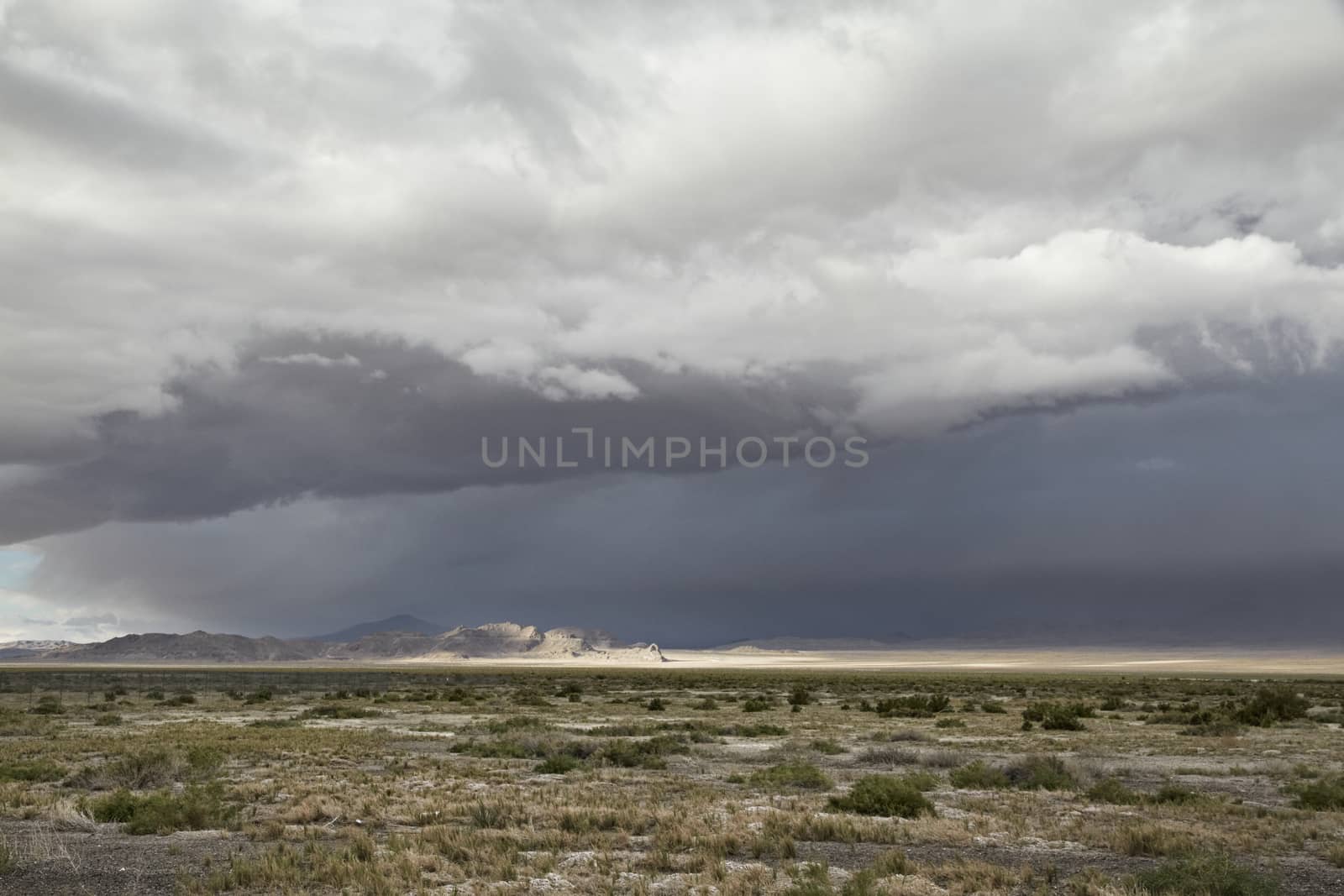 Prarie landscape beneats a dark bluegrey clouded sky