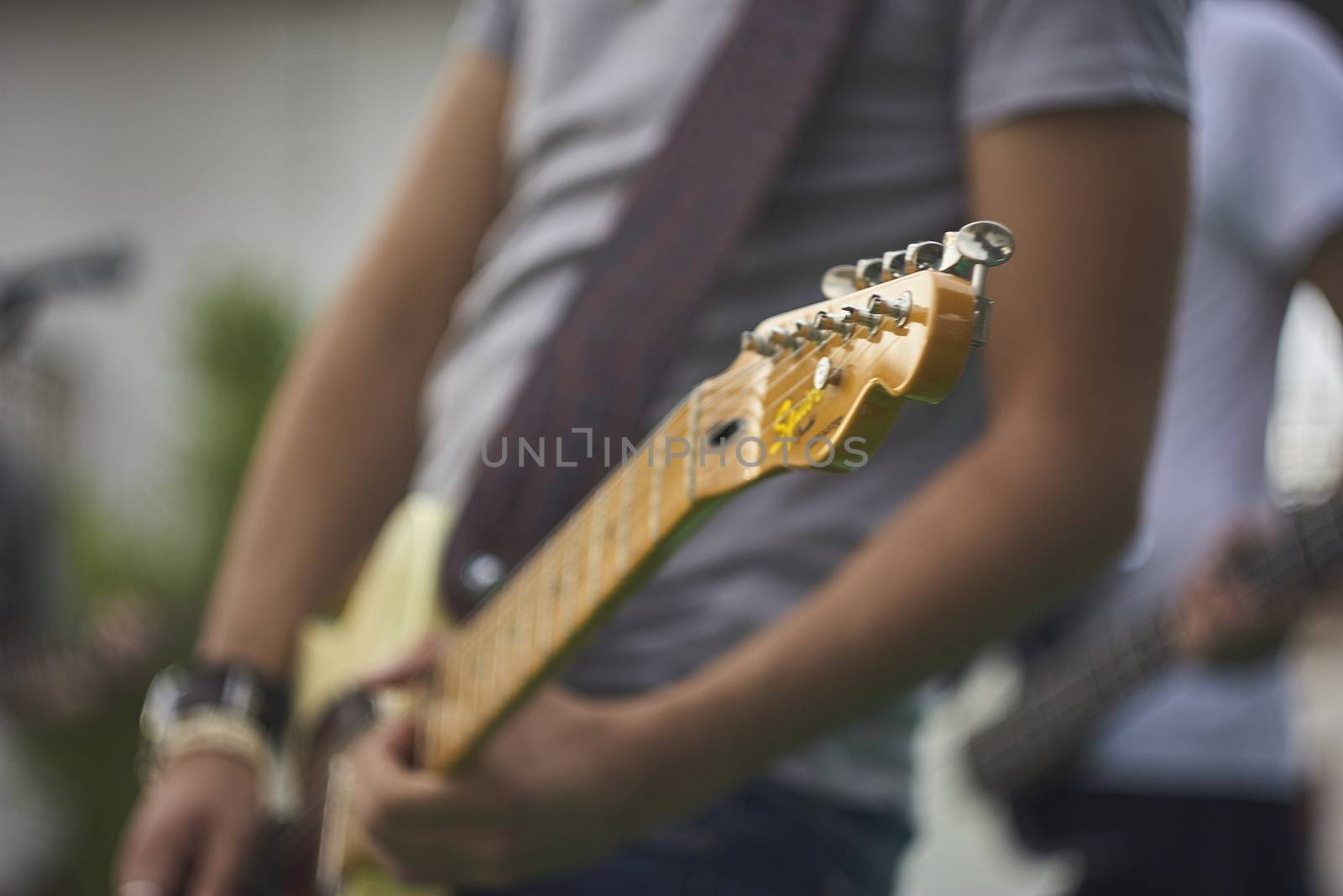 Detail of a Guitarist who plays his electric guitar at a live rock music concert.