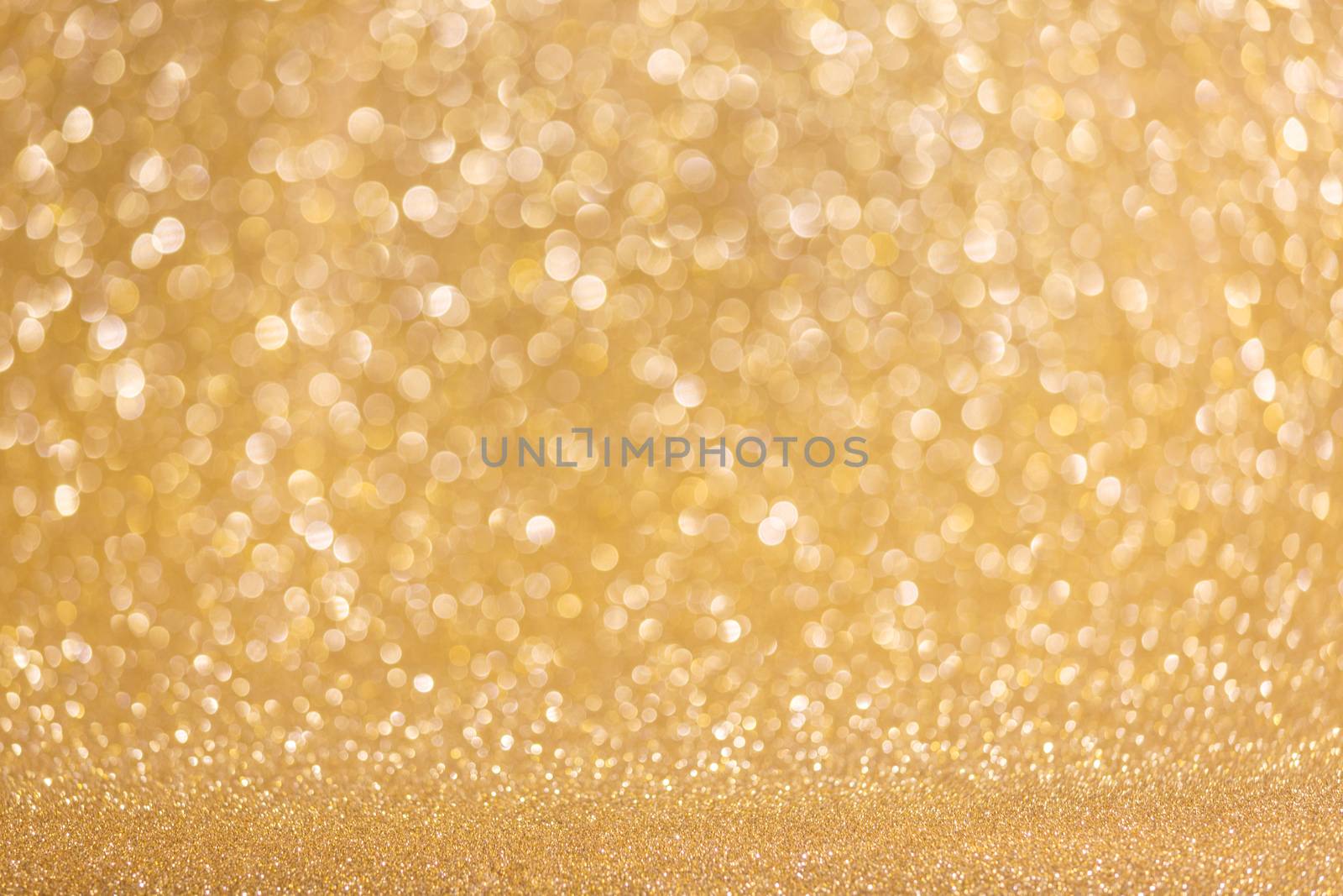 Golden festive glitter background with defocused lights