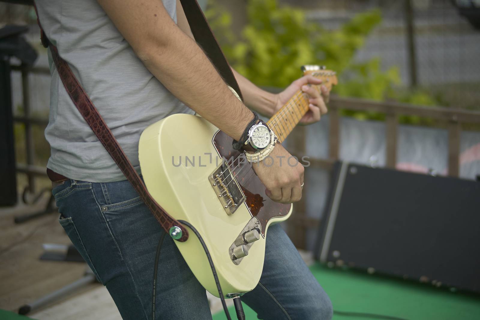 Detail of a Guitarist who plays his electric guitar at a live rock music concert.