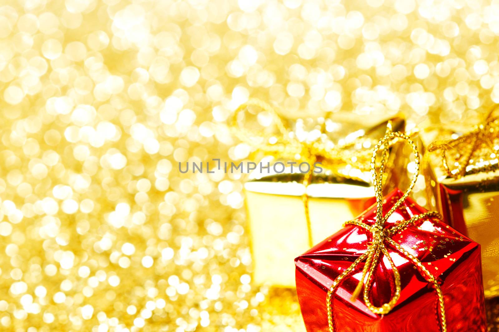 Decorative boxes with holiday gifts on abstract gold background
