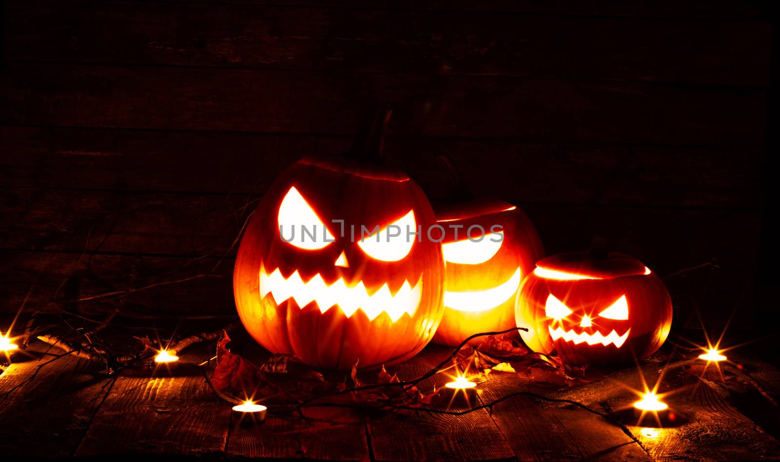 Halloween pumpkin head jack o lantern and candles on gray background