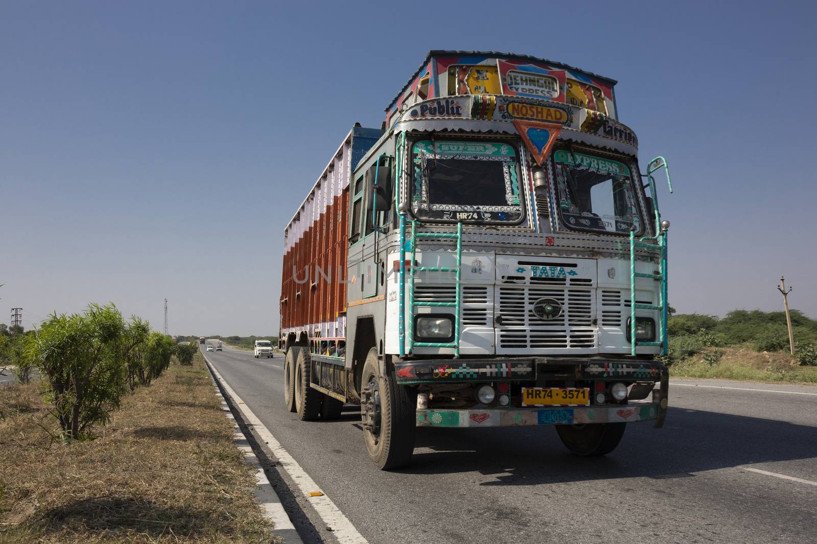 Colorful trucks brand TATA in Indian highway by Tjeerdkruse