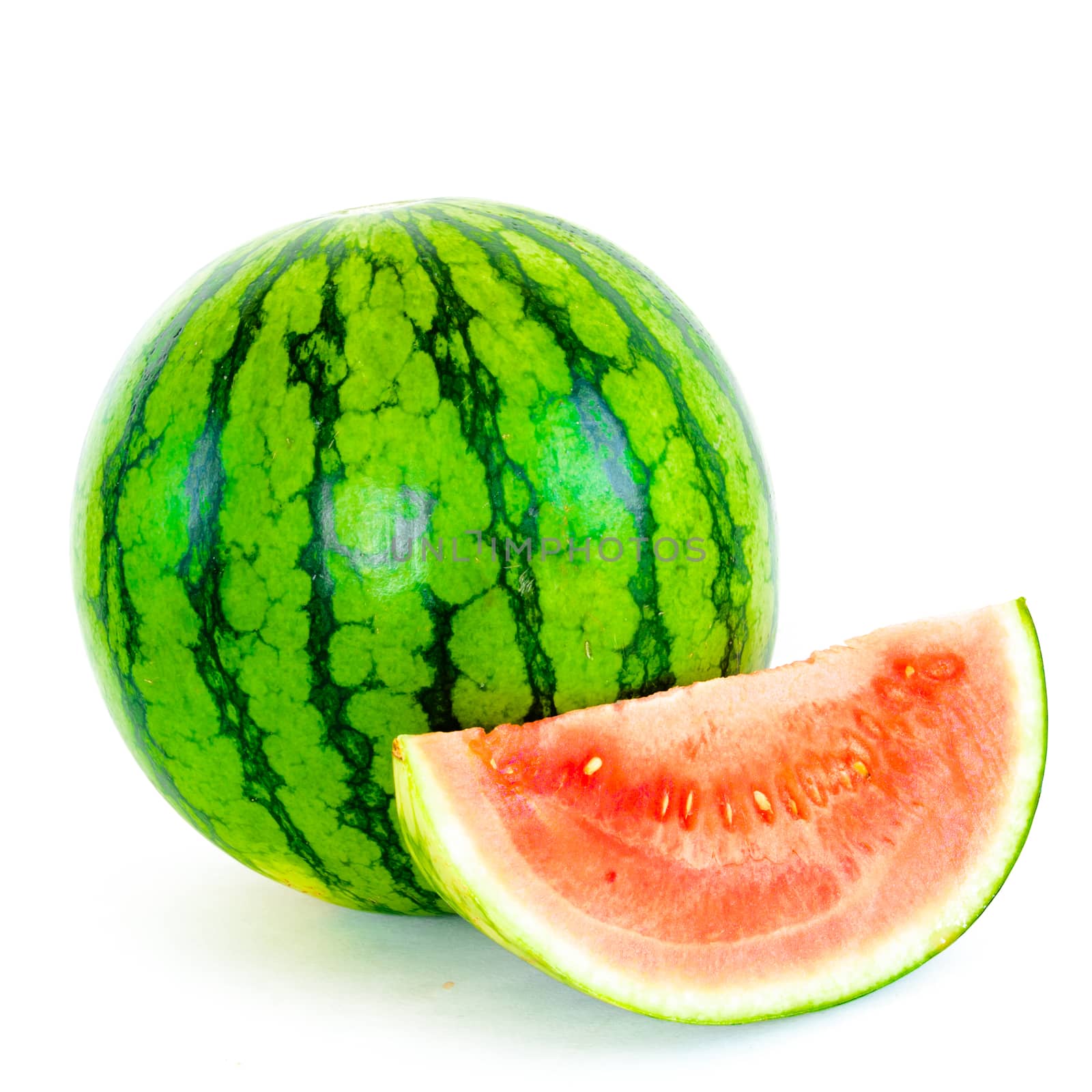 A whole organic mini watermelon with long slice cut isolated on white background.