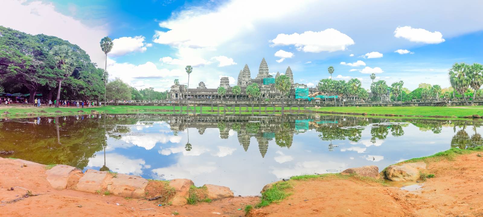 Panoramic view Angkor Wat facade under construction and palm tree reflection on the lake by trongnguyen
