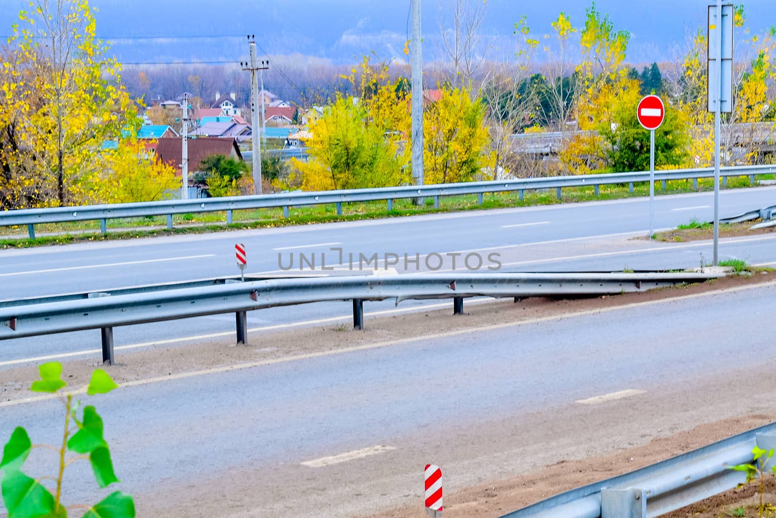 road with fences and signs in autumn day by alexandr_sorokin