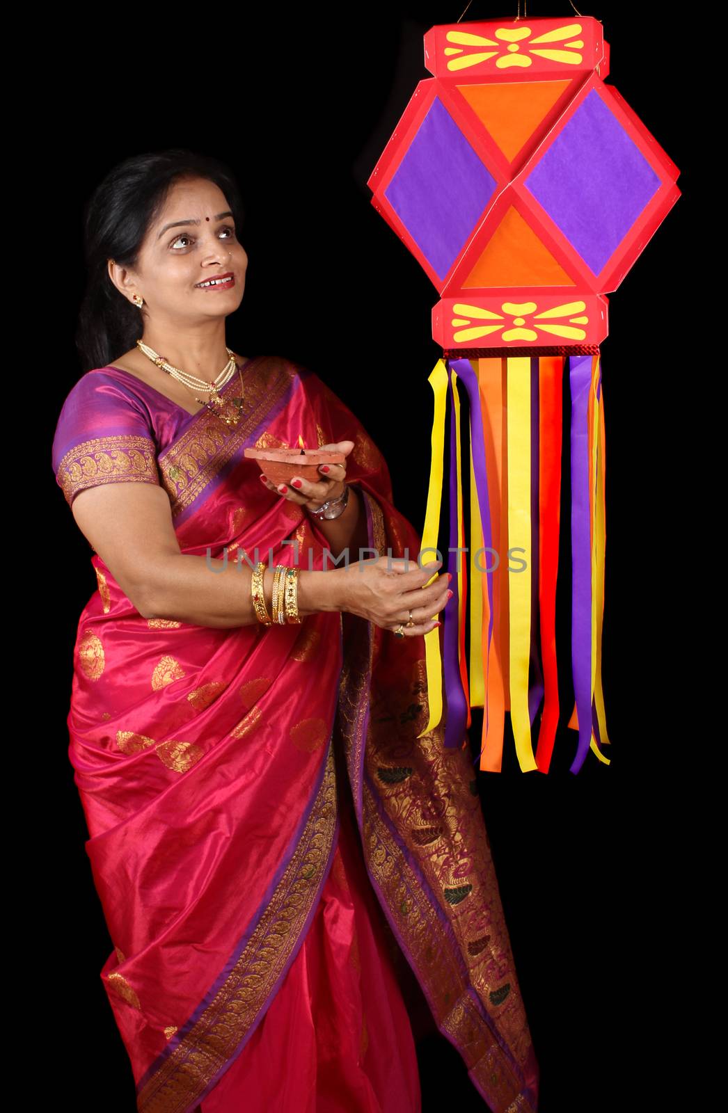 An Indian woman holding a traditional Diwali lamp adoring her Diwali lantern also called as sky lantern