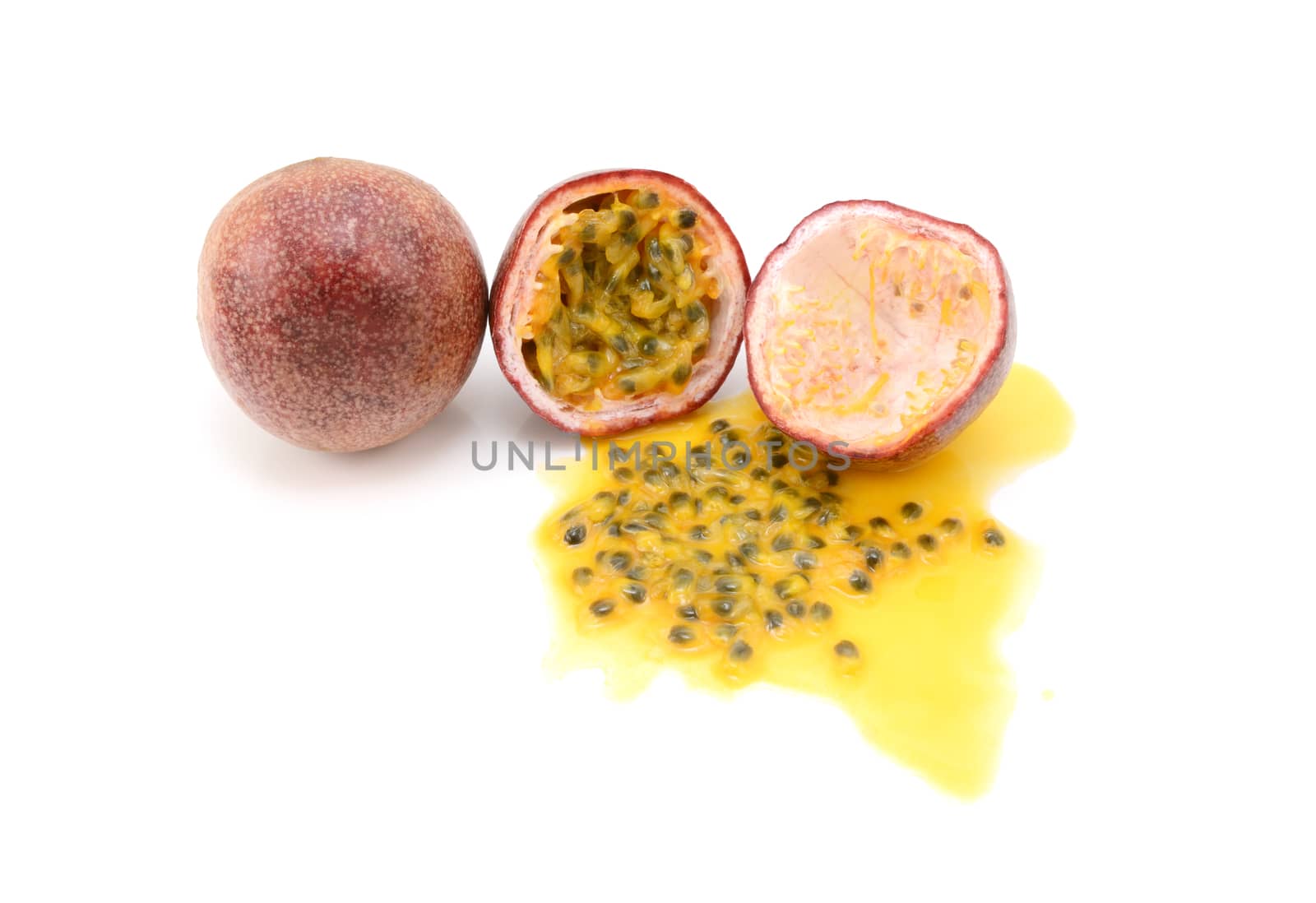 Whole and halved passion fruits with spilled juice and seeds by sarahdoow