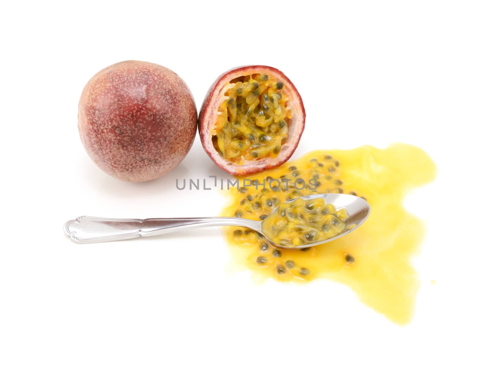 Whole passion fruit and half-eaten cross section with spoon by sarahdoow