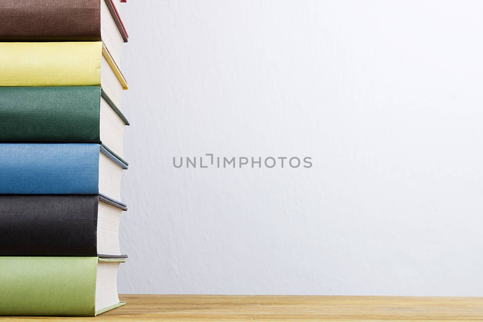 Stack of books with colorful covers on a wooden table