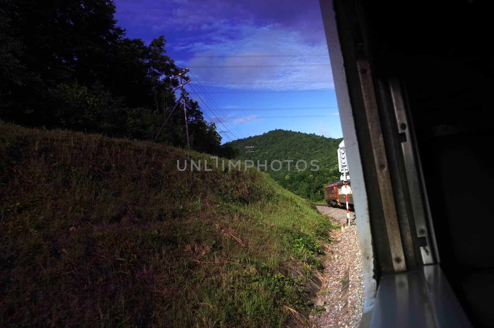 View from train window in motion of countryside and sky on sunny warm , in Thailand , Effect saturation