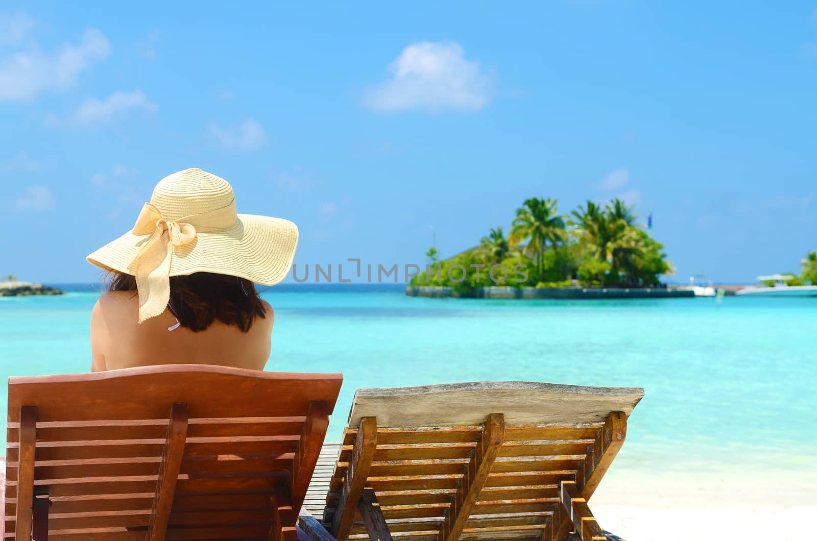 Woman on sunbed relaxing  at tropical  Maldives island. Travel and Vacation.