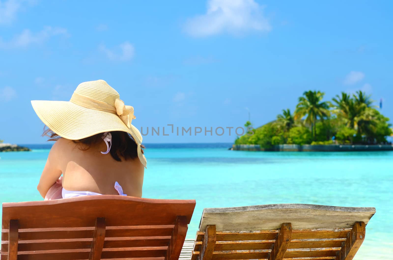 Woman on sunbed relaxing  at tropical  Maldives island. Travel and Vacation. 