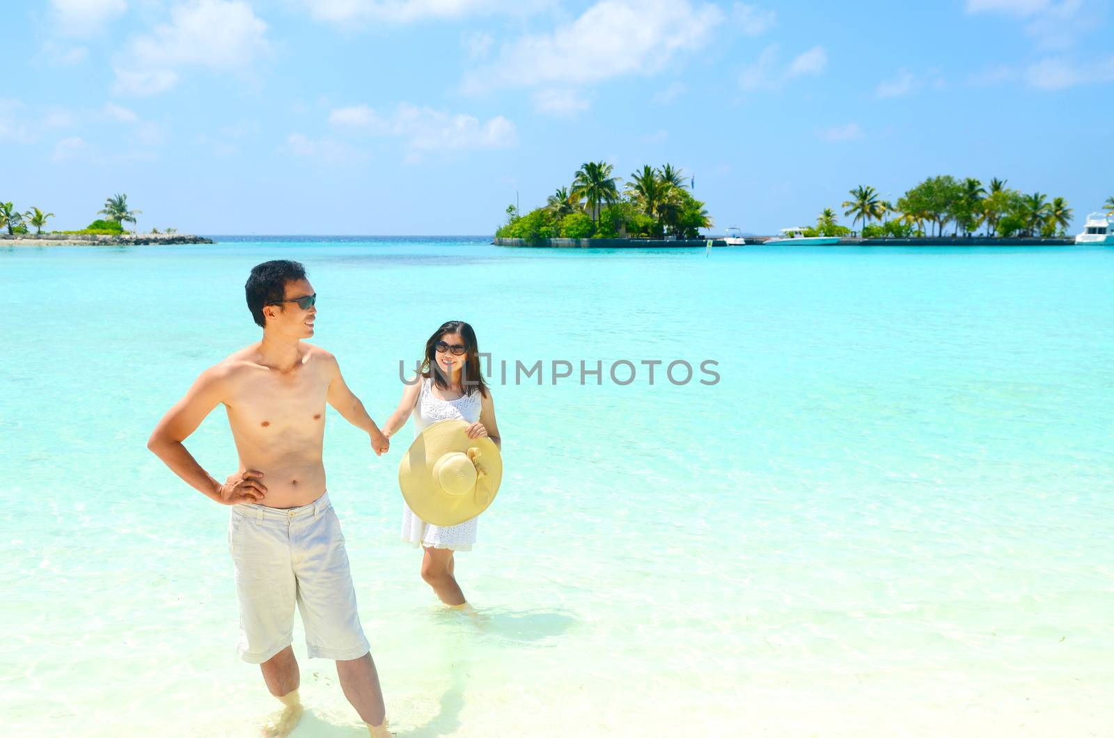 Loving asian couple  in clean water at summer vacation in Maldives island