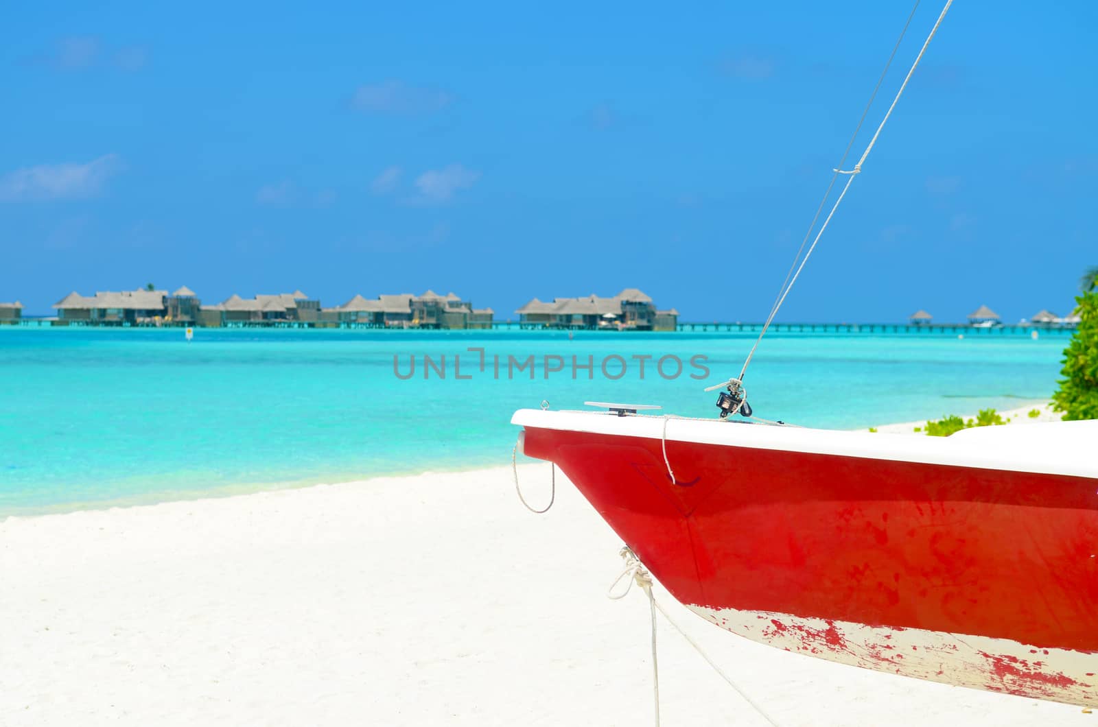 Boat on the white sand beach at maldives island