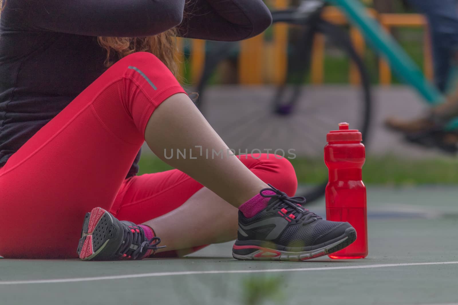 Woman adjusting her tennis shoes by leo_de_la_garza