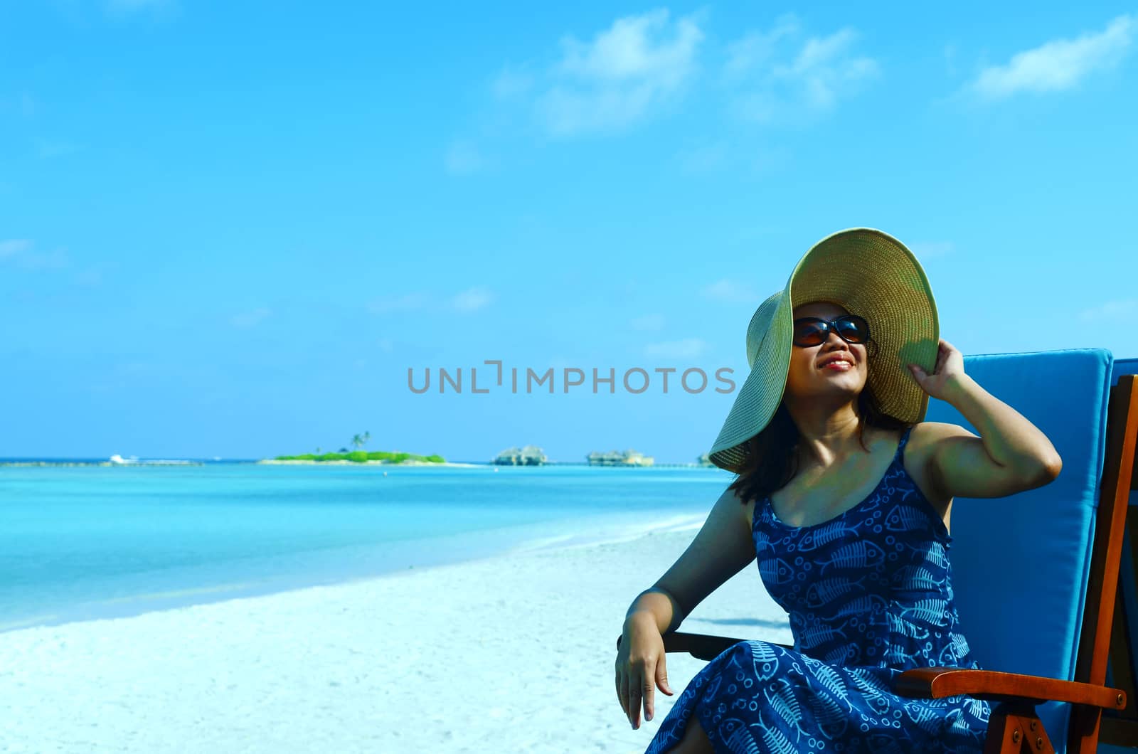 close-up portrait of a beautiful young asian girl with long hair on a background of blue sea and sky with clouds on a sunny day, lifestyle, posing and smiling.