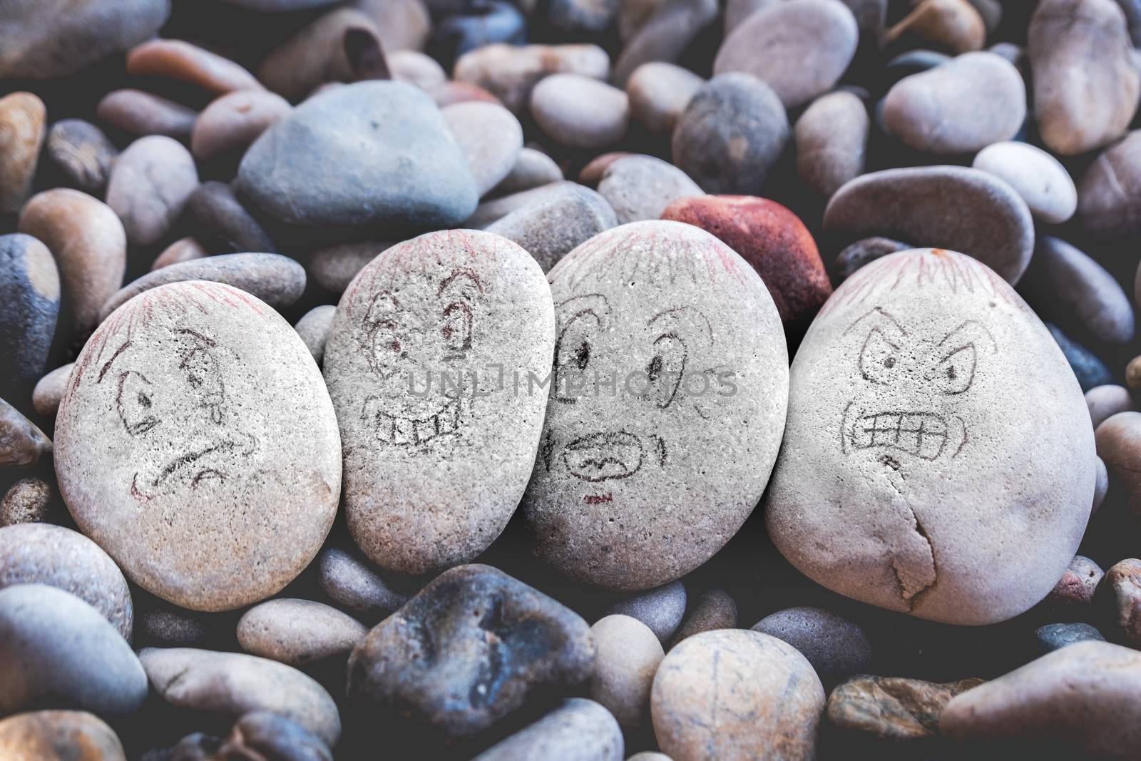 managing emotions emoji faces on stones - sad, happy, surprised worried and angry draw by LucaLorenzelli