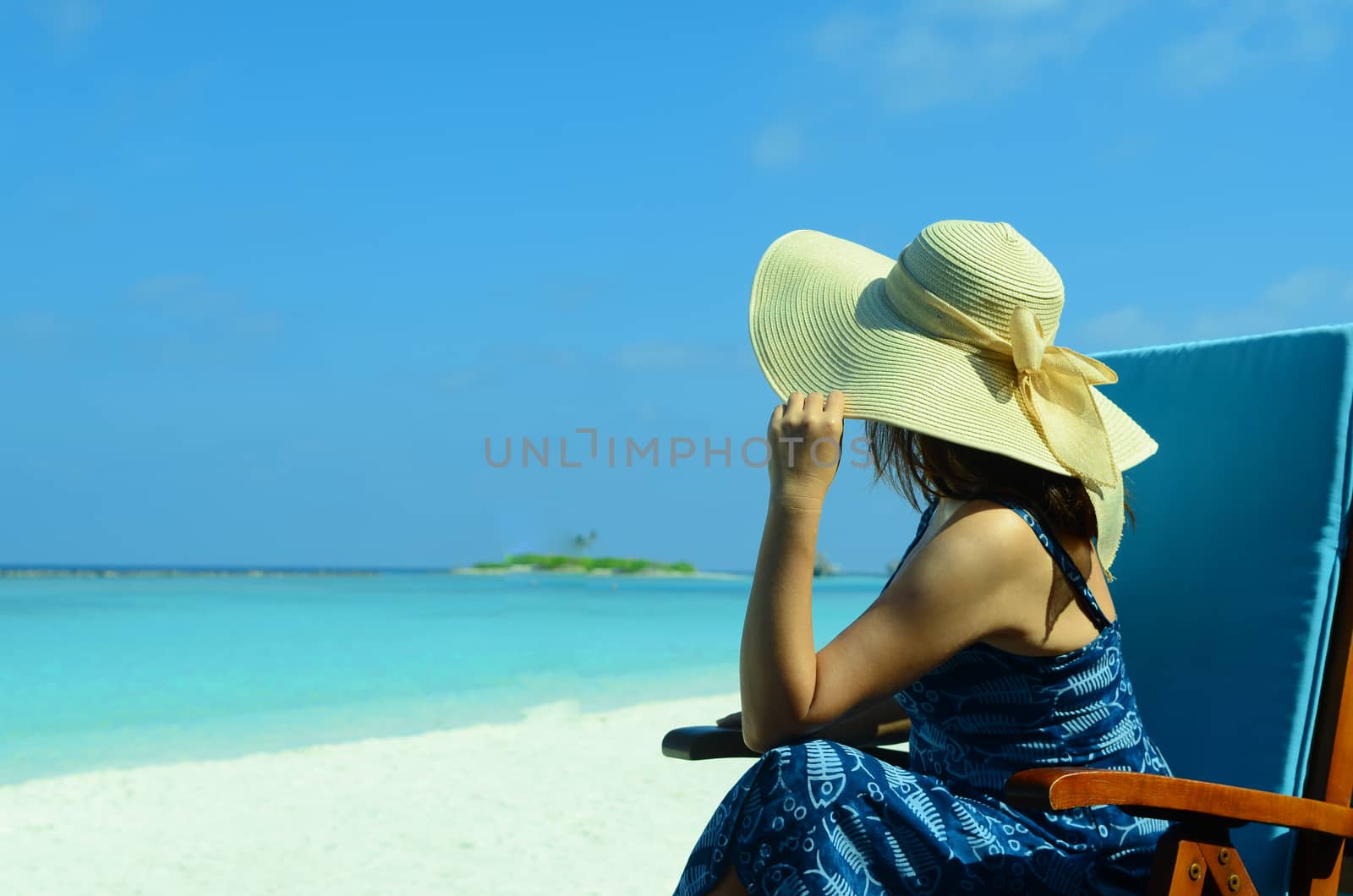 close-up portrait of a beautiful young asian girl with long hair on a background of blue sea and sky with clouds on a sunny day, lifestyle, posing and smiling.