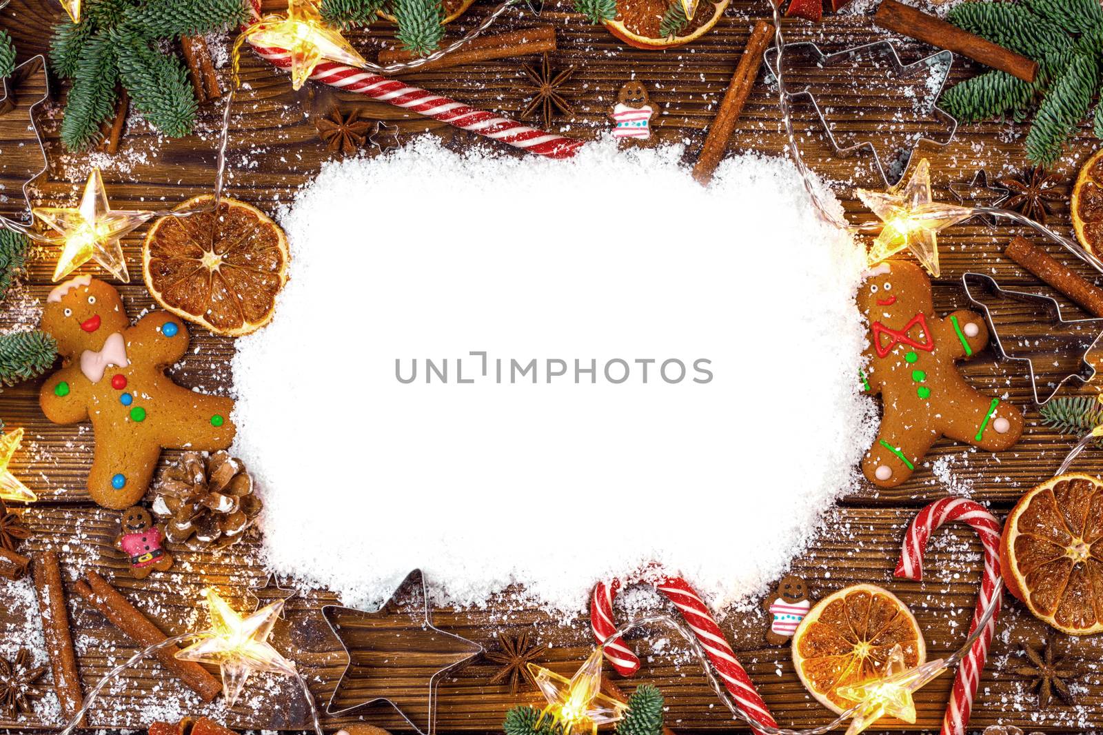 Christmas food frame. Gingerbread cookies, spices and decorations on wooden background with copy space on snow