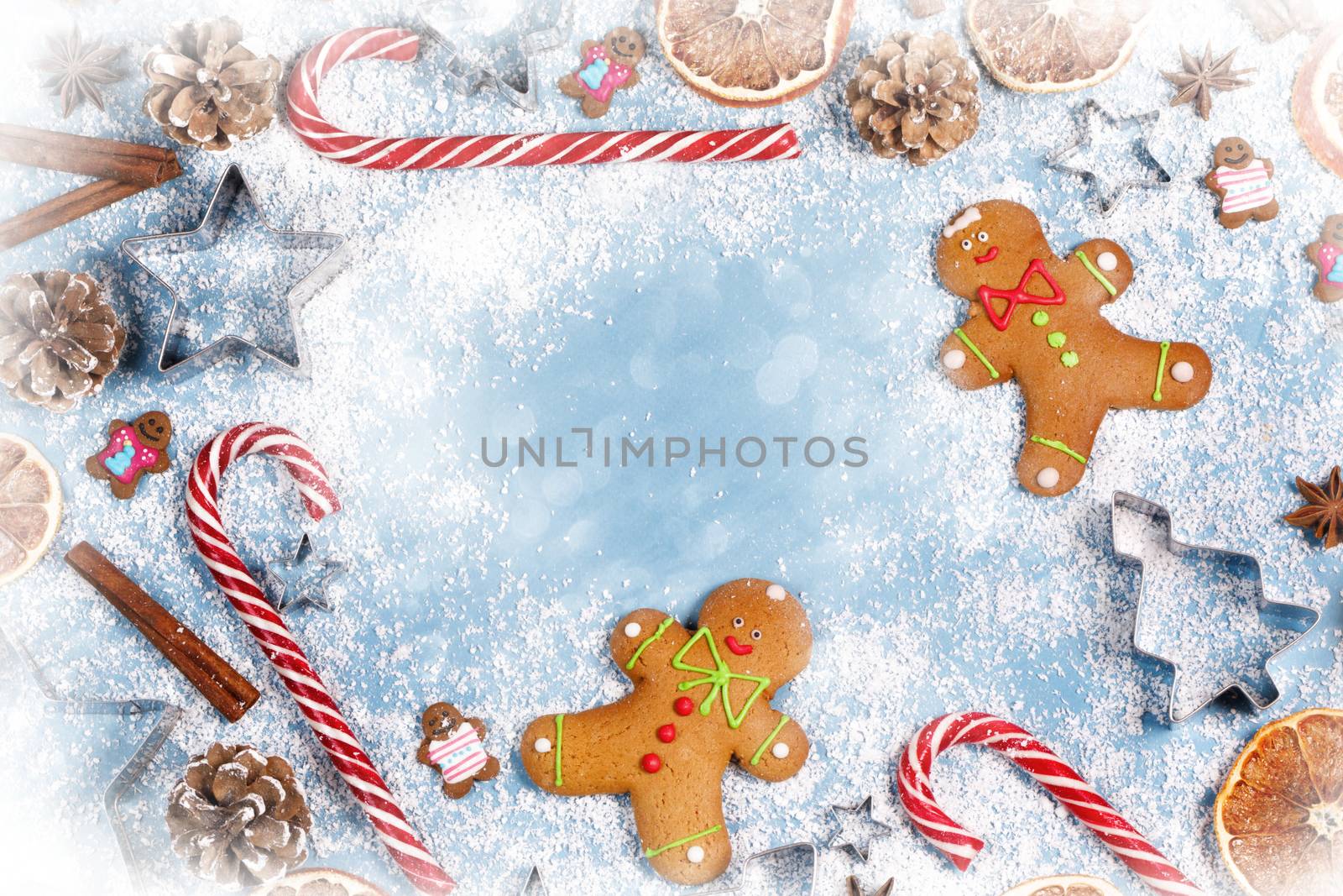 Christmas food frame. Gingerbread cookies, spices and decorations on blue background with copy space