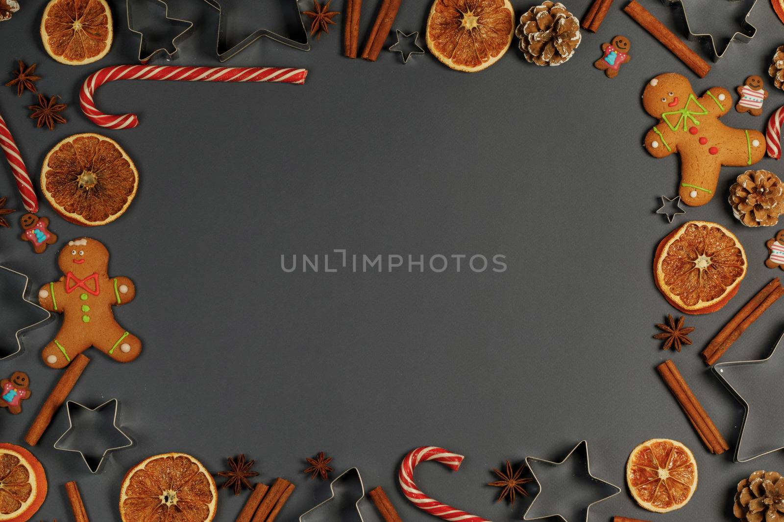 Christmas food frame. Gingerbread cookies, spices and decorations on gray background with copy space