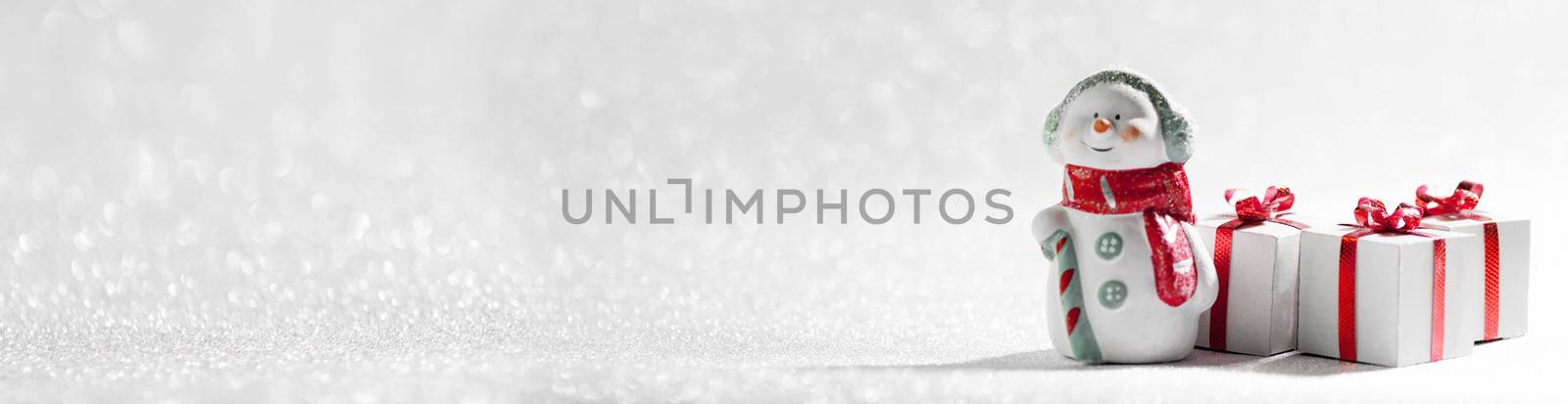 Christmas Snowman toy and gifts on silver glitter background