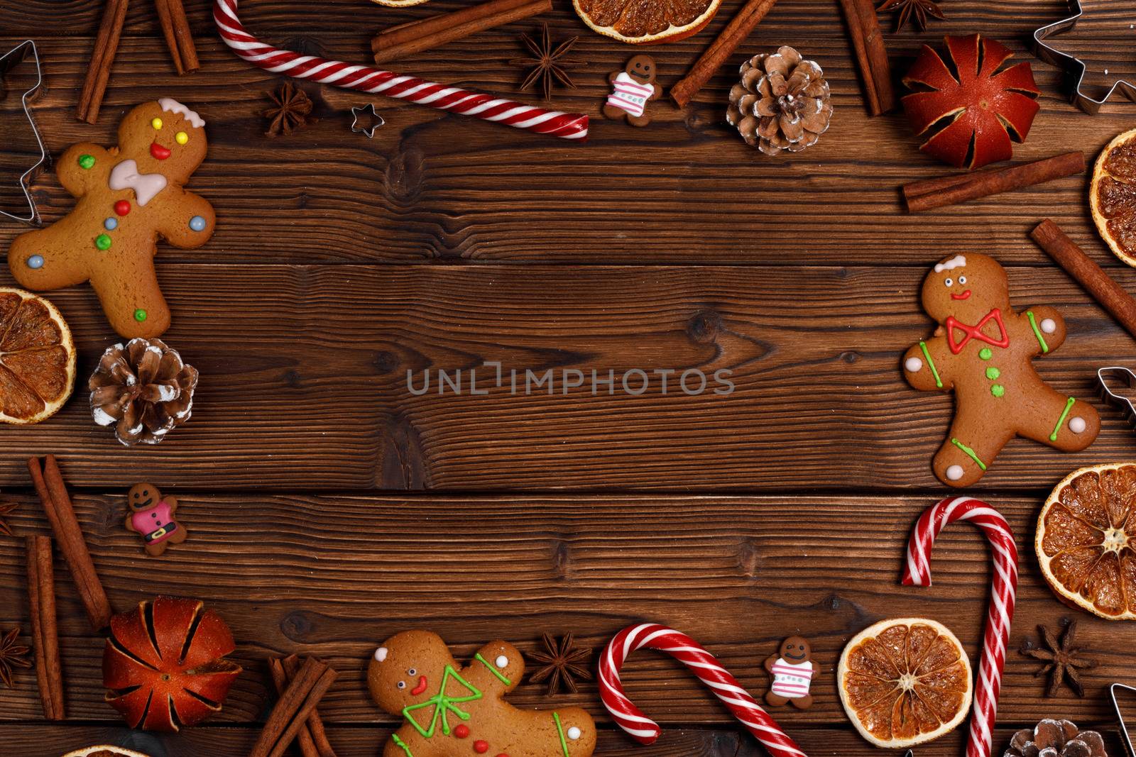 Christmas food frame. Gingerbread cookies, spices and decorations on wooden background with copy space