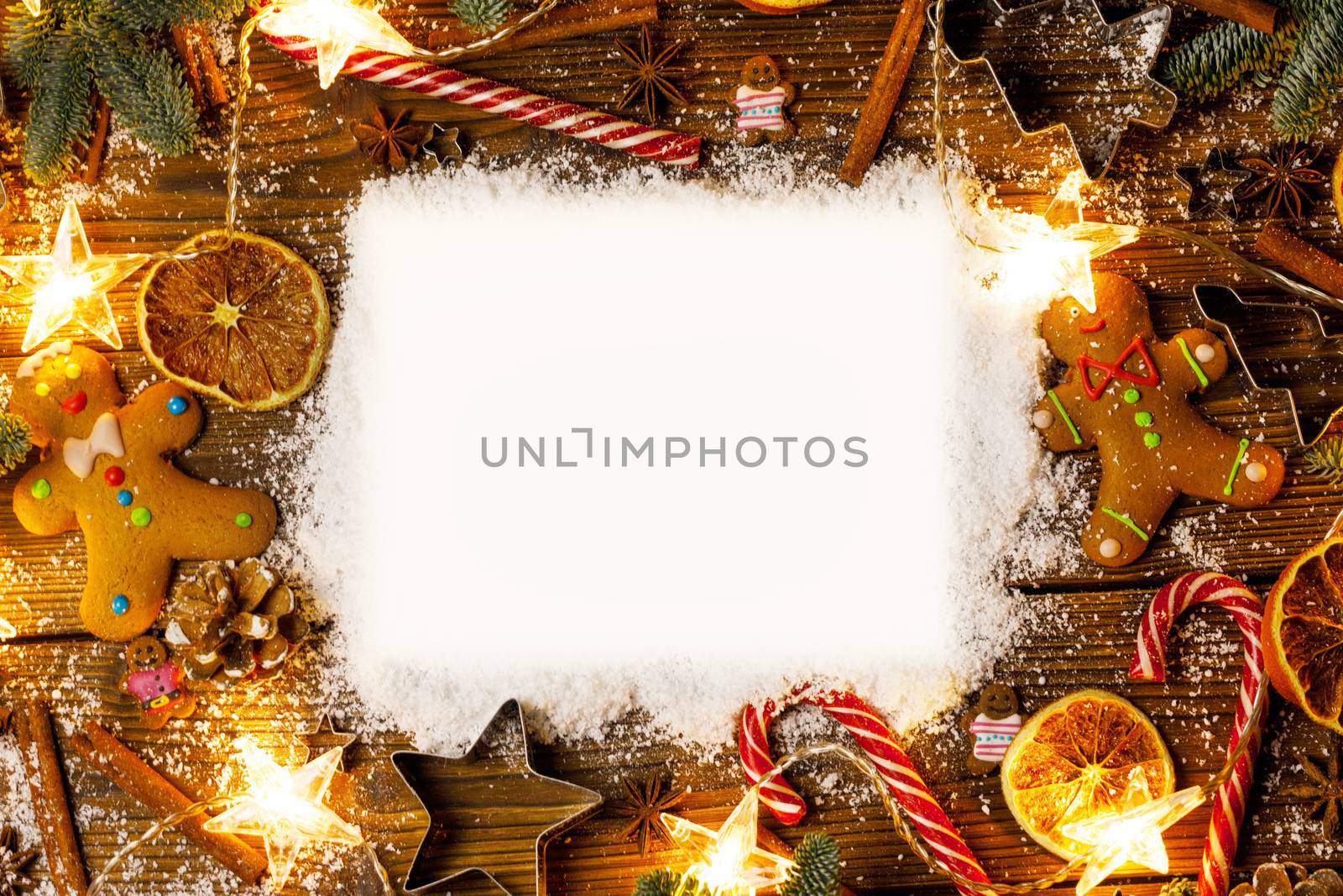 Christmas food frame. Gingerbread cookies, spices and decorations on wooden background with copy space on snow