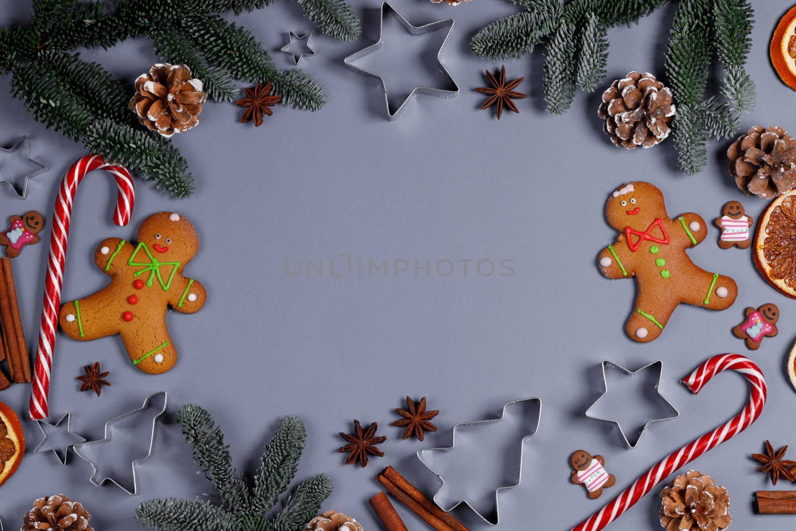 Christmas food frame. Gingerbread cookies, spices and decorations on gray background with copy space