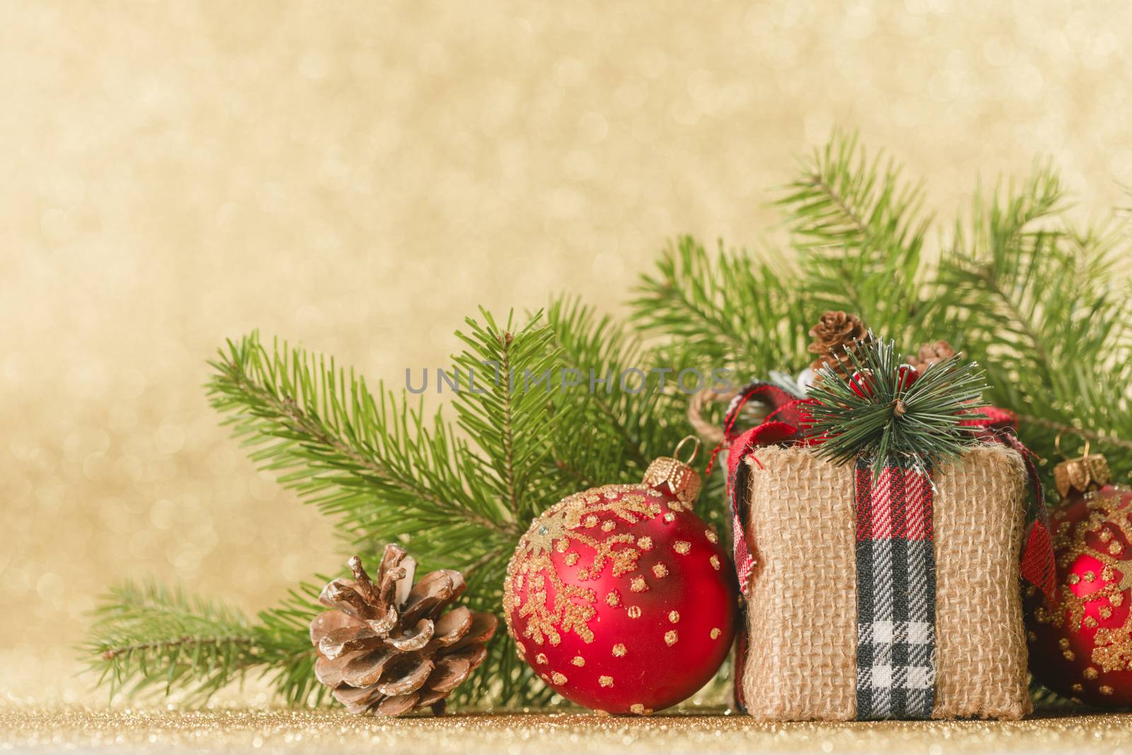 Christmas toys, decorations, present gift box wrapped in kraft paper on golden glitter background, copy space