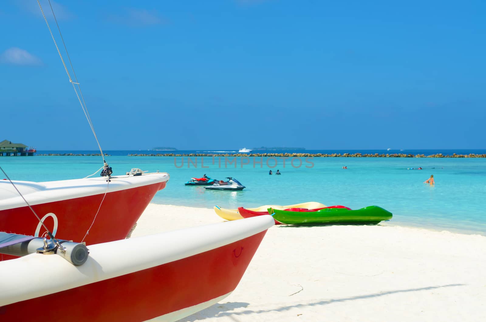 Boat on the white sand beach at maldives island