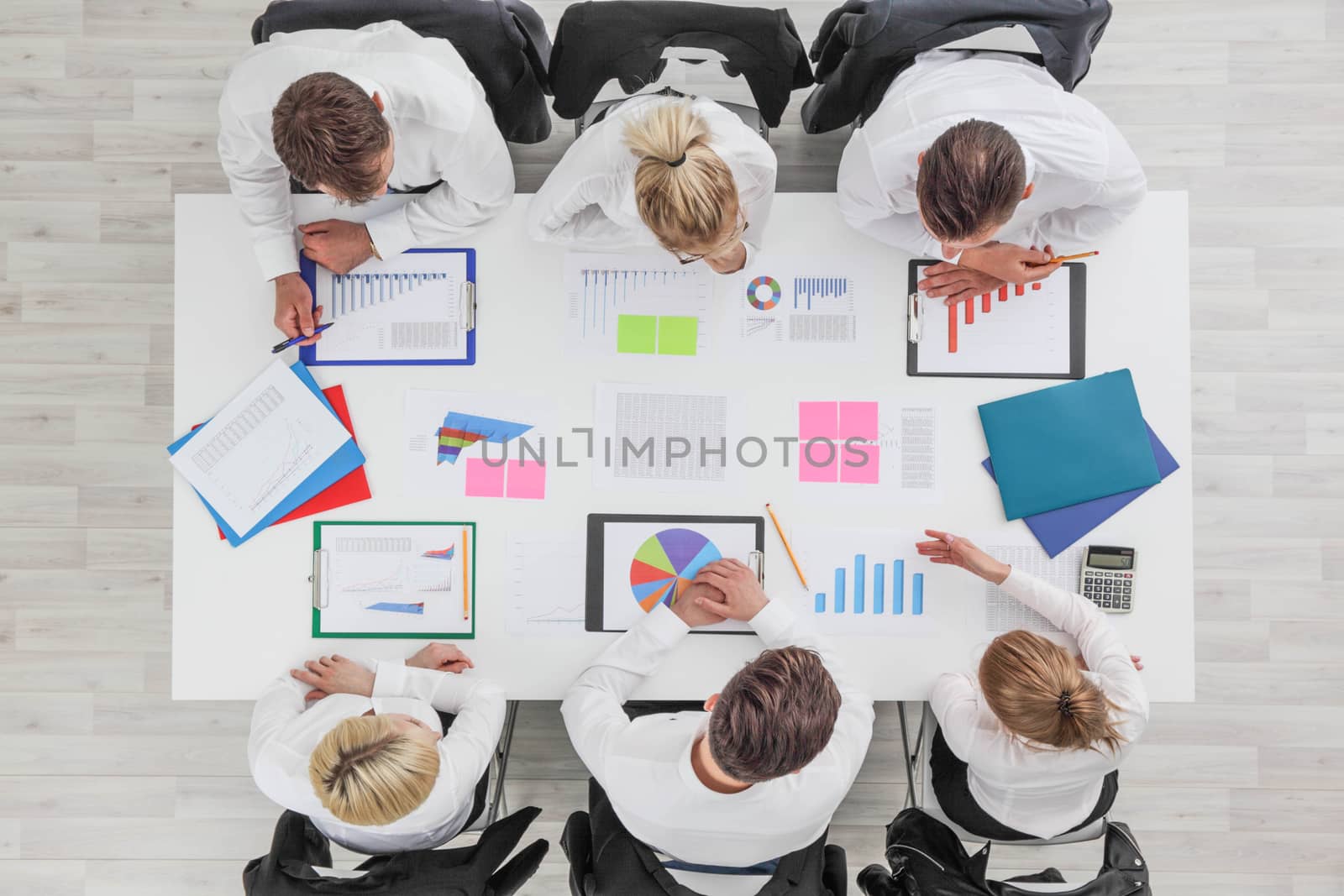 Business people work with statistics documents with tables and diagrams sitting around the table
