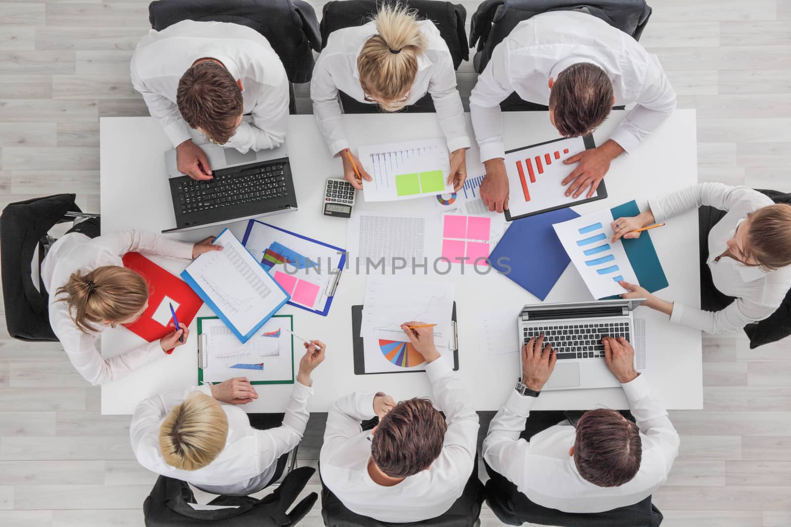 Business people work with statistics documents with tables and diagrams sitting around the table